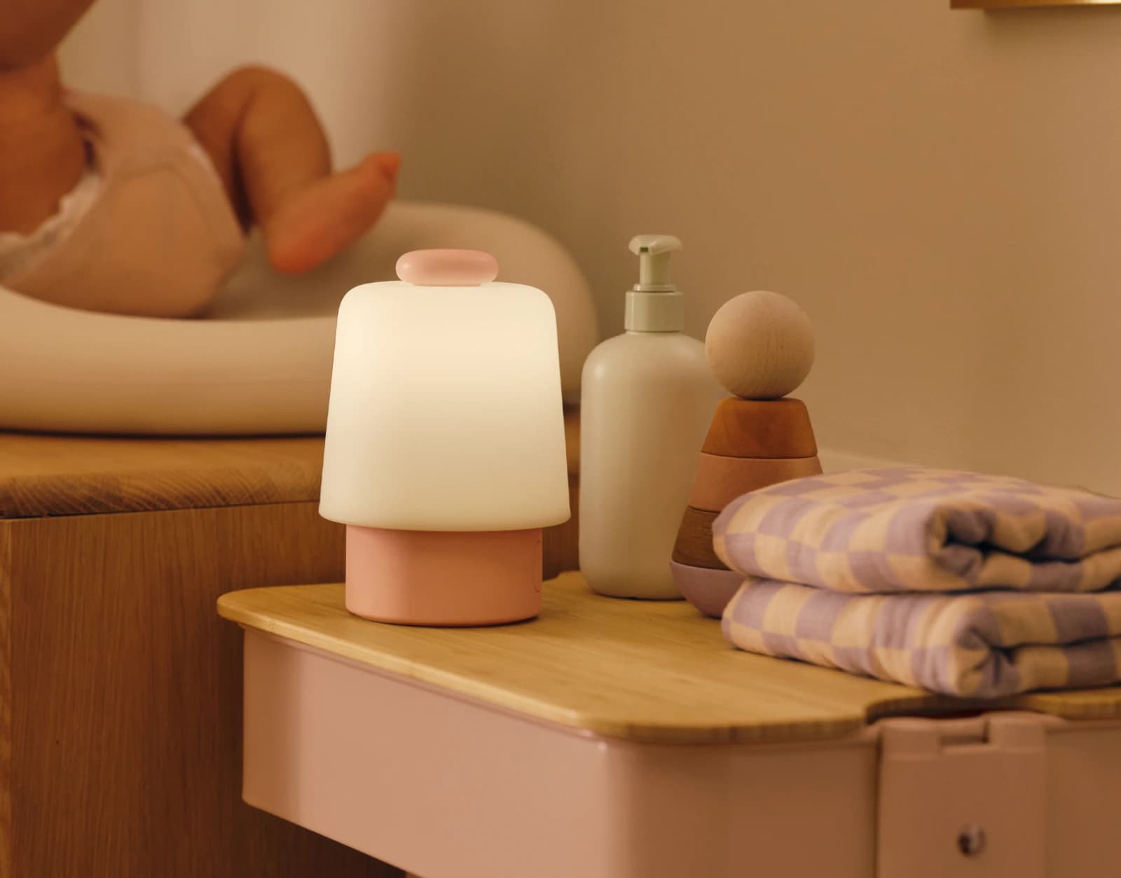 Hatch Baby Peach sitting on a nursery changing table