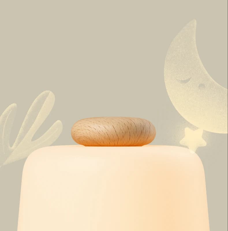 Closeup of Hatch Baby top button on a moon and leaf background