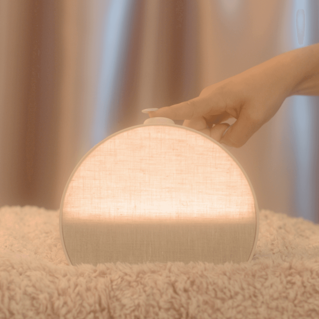 Hand tapping the top button on a Hatch Restore 3